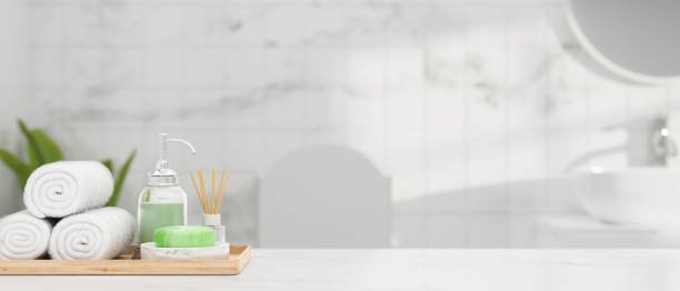 istock White marble table top with hand towels, soap, shampoo, aroma diffuser and mockup space over bathroom interior, 3d rendering 1339943259