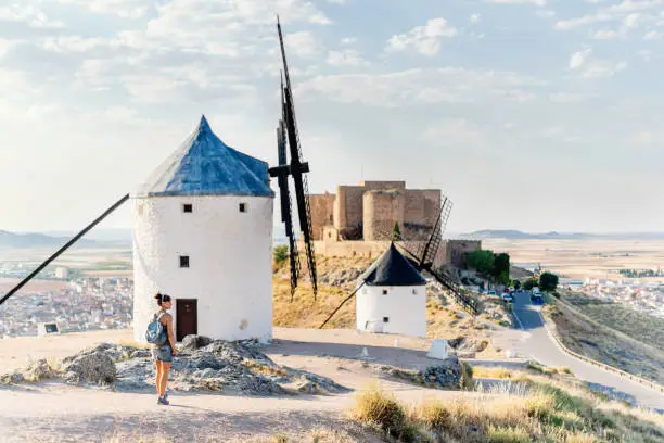 Photo of Tourist on a hill with a group of restored windmills and a castle