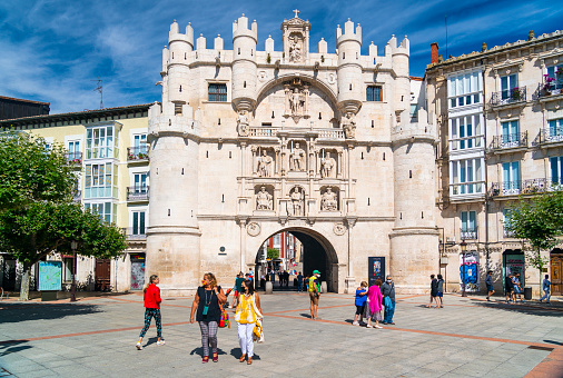 Burgos, Spain - August 1, 2021: People walking in front of the Arco de Santa Maria in Burgos, Spain which was built in the 1500's.