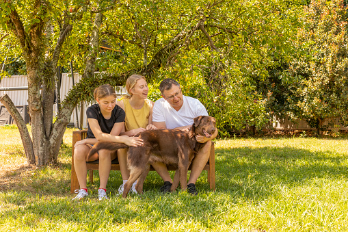 Father Sitting in the Backyard With His Teenage Daughters