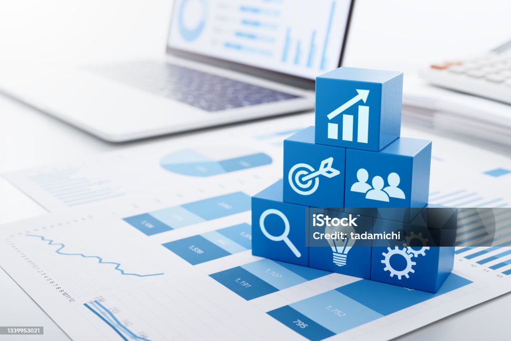 Business strategy for marketing and management. Stacked blue blocks, reports and laptop. Chart Stock Photo