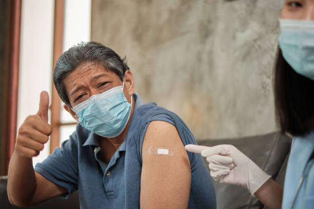 istock Elderly patient with face mask thumb up when vaccinated. 1339955059