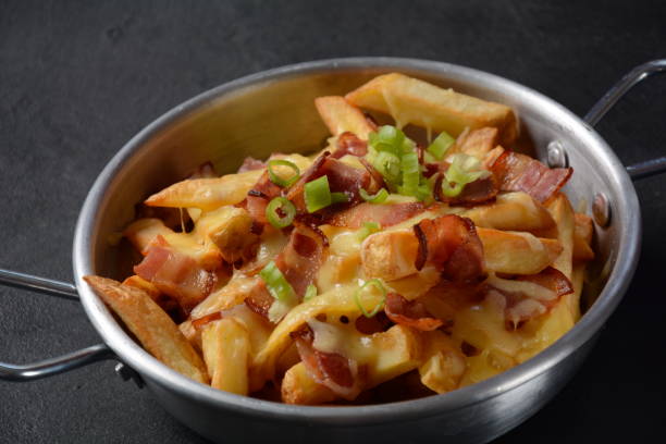 istock French fries with Melted Cheddar Cheese with Crispy Bacon. Poutine with cheese, bacon and green onions 1339955630