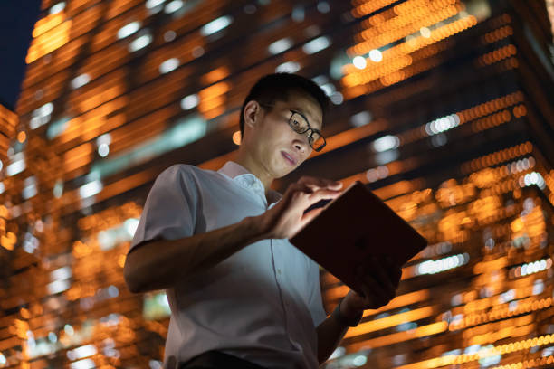 istock Man using tablet in central business district at night 1339958187