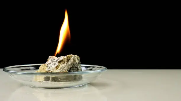 Photo of Calcium carbide or CaC2 reacts on contact with water and produces flammable acetylene gas. A fire created by burning acetylene gas