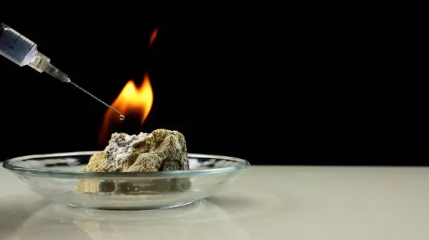 Photo of Calcium carbide or CaC2 reacts on contact with water and produces flammable acetylene gas. A fire created by burning acetylene gas