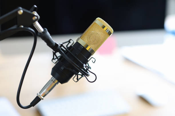istock Golden microphone standing on table in recording studio closeup 1339960362