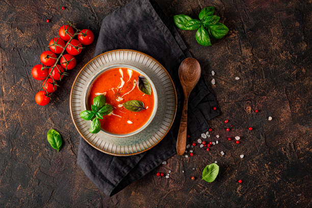 어두운 배경 상단에 크림과 바질전통적인 스페인 토마토 수프 그릇. 회색 그릇에 토마토와 바질 가스파초 - tomato soup red basil table 뉴스 사진 이미지