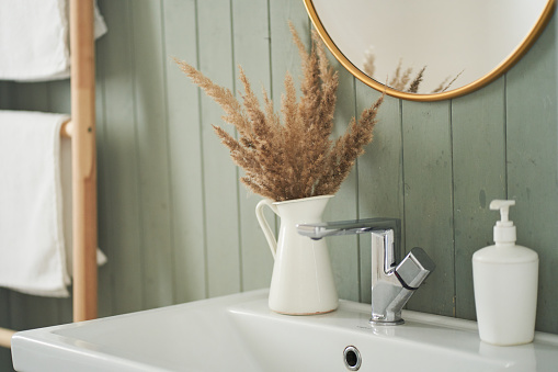 A modern bathroom interior with a minimalist decor, a sink and a round mirror in a stylish bathroom. Interior design. High quality photo