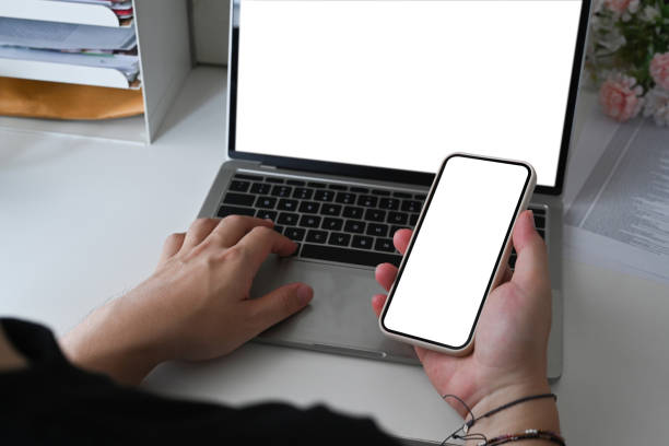 istock Young man using laptop computer and holding smart phone. 1339962281