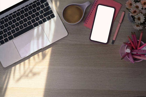 istock Above view laptop computer and smart phone on wooden table. 1339963386