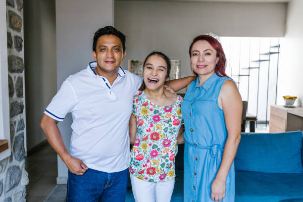 padres latinos e hija adolescente con parálisis cerebral en sala de estar en casa en la ciudad de méxico en concepto de discapacidad - cultura mexicana fotos fotografías e imágenes de stock