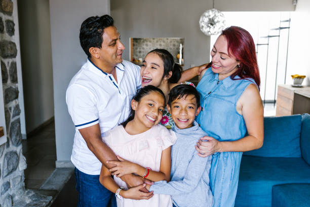 retrato de una feliz familia hispana y una hija adolescente con parálisis cerebral en casa en américa latina en concepto de discapacidad - child group of people teenager sibling fotografías e imágenes de stock