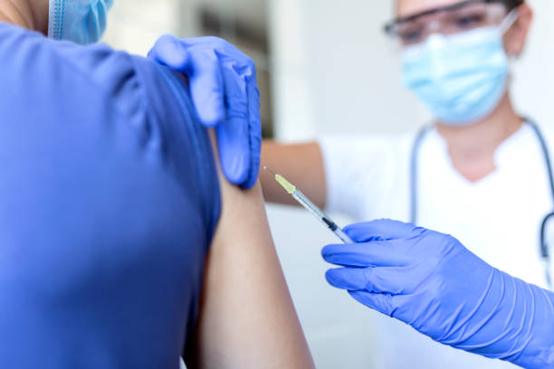 istock General practitioner vaccinating old patient in clinic with copy space. Doctor giving injection to senior man at hospital. Nurse holding syringe before giving Covid-19 or coronavirus vaccine. 1339969015