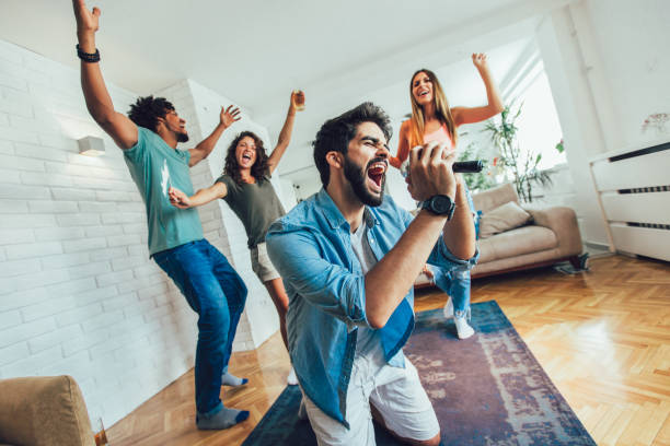 gruppo di amici che giocano al karaoke a casa. - karaoke foto e immagini stock