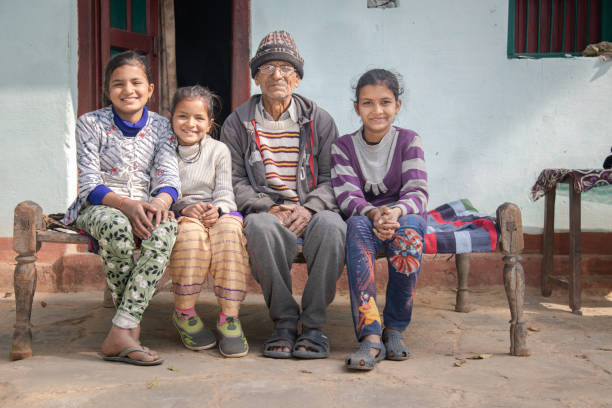pai e filhas indianos sentados juntos - india slum poverty family - fotografias e filmes do acervo