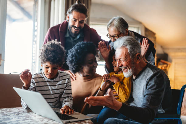 Portrait of a happy multigeneration family using electronic devices at home together Portrait of a multiethnic happy multigeneration family using electronic devices at home together three generation family stock pictures, royalty-free photos & images