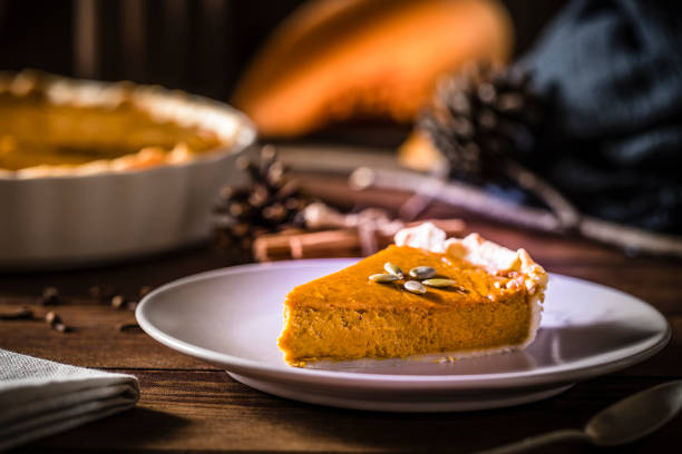 Front view of a portion of pumpkin pie on a rustic wooden table
