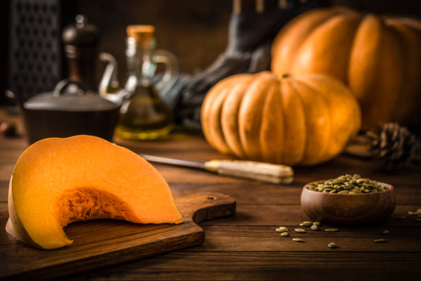 istock Sliced pumpkin with pumpkin seeds on a wooden table 1339982709