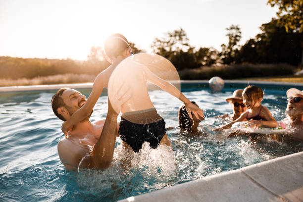 istock Cheerful father and son having fun in the swimming pool. 1339982918