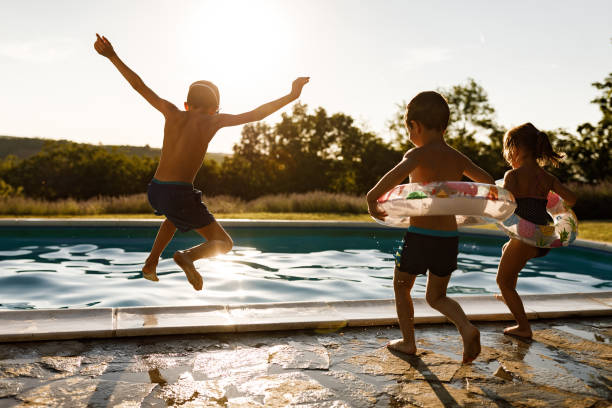 istock Playful siblings having fun during summer day at the pool. 1339983381