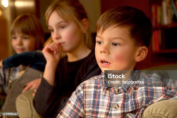 Gruppo Di Bambini Di Guardare La Tv Attenzione Al Ragazzo Davanti - Fotografie stock e altre immagini di Bambino