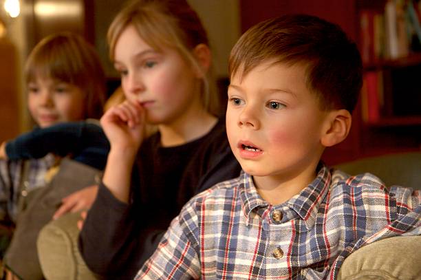 istock children group watching tv, focus at the boy in front 133998467