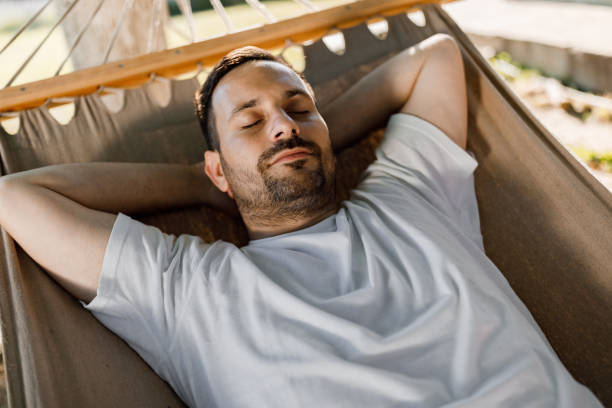istock Relaxed man taking a nap in hammock. 1339985587