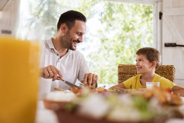 istock Happy single father talking to his boy during breakfast at home. 1339985843
