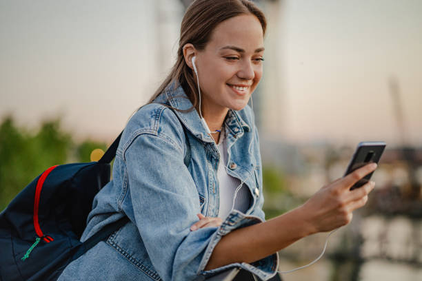 istock Young woman relaxing by the river and using mobile phone 1339986891