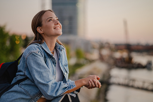 Beautiful woman relaxing by the river and smiling