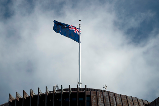 Wellington, New Zealand - 23 October, 2020: Close up New Zealand flag on Beehive, the parliament building of New Zealand.