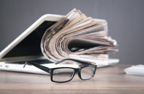 istock Newspapers, computer, eyeglasses on the wooden table. 1339990566