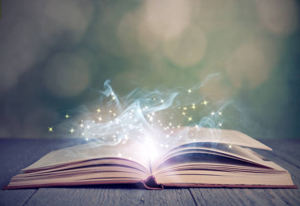 istock Open book with magic glowing on wooden table. Fairy tale 1339992419