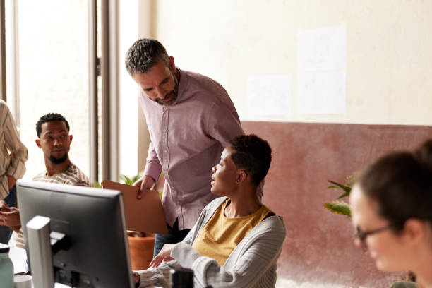 istock A leader checking on the team members in an office. 1339994002
