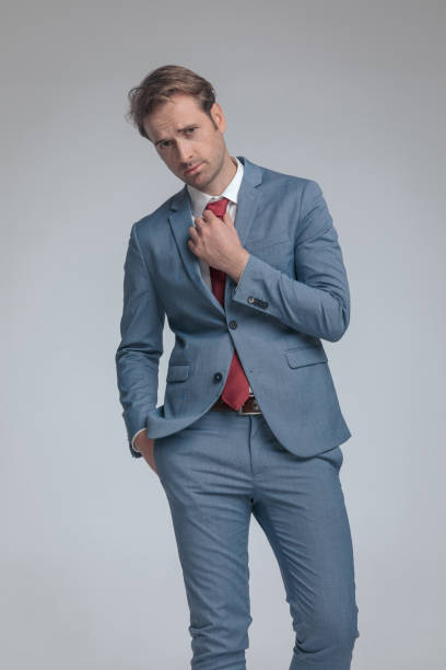 istock businessman sticking one hand in pocket while fixing his tie 1339994213