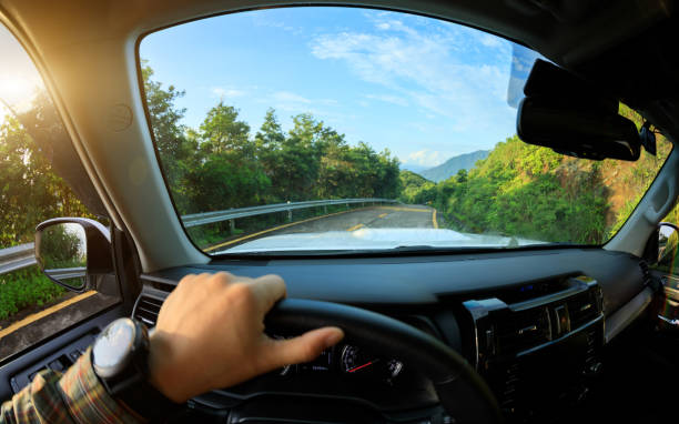 istock People driving car on sunrise mountain road 1339998592