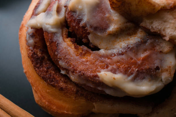 Close up of cinnamon roll on black background.