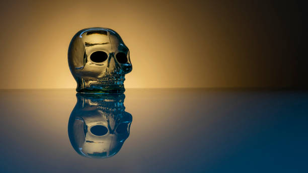 glass skull with reflection on the table. halloween glass skull with reflection on the table. halloween Aflame stock pictures, royalty-free photos & images