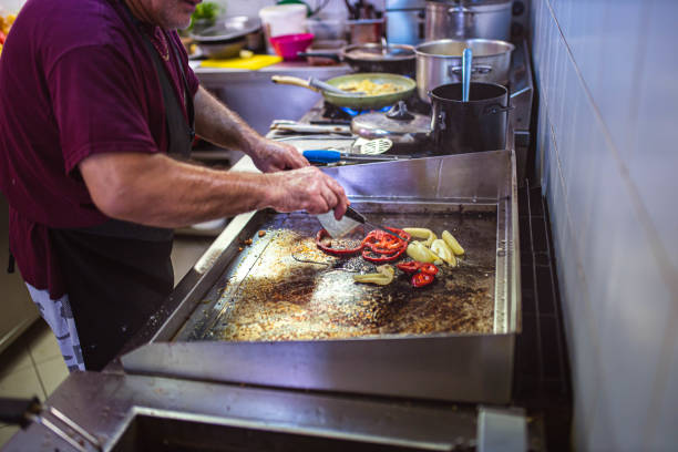 Chef preparing savory meat inside dimly lit food truck, crafting authentic mexican street food during nighttime culinary rush