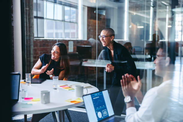 istock Cheerful businesspeople laughing while clapping their hands in a 1340003506