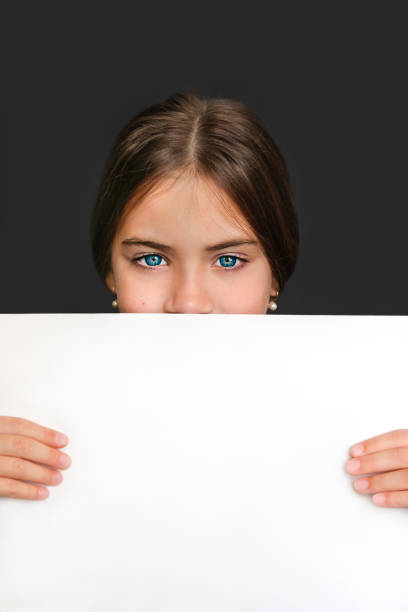 istock Girl with white blank sheet close up 1340004036