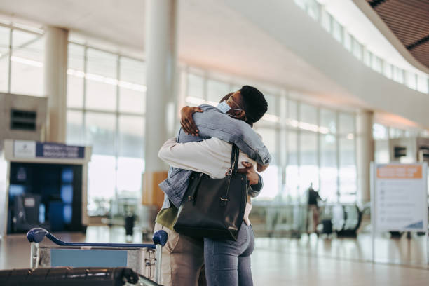 Wife giving good bye hug to her husband at airport Couple embracing each other before departing at airport. Wife giving good bye hug to her husband at airport departure gate. airport hug stock pictures, royalty-free photos & images