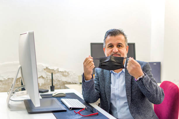 istock Businessman working at his desk with mask 1340006031