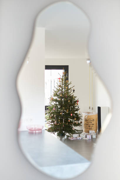 A modern decorated Christmas tree under which wrapped Christmas presents