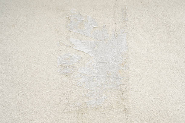 Old ripped torn grunge white poster texture on concrete wall background