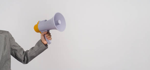 istock Hand is hold megaphone and wear grey suit on white background. 1340010135