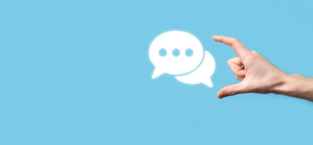 istock Businessman holding a message icon, bubble talk notification sign in his hands. Chat icon, sms icon, comments icon, speech bubbles 1340010346