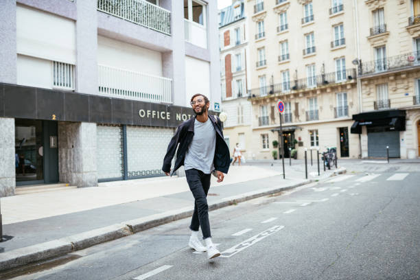 Young urban guy crossing the street