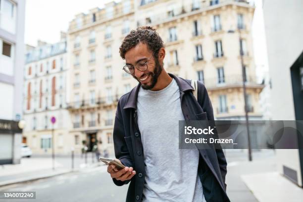 Modern Young Man With Curly Hair In The City Stock Photo - Download Image Now - Men, Using Phone, Paris - France